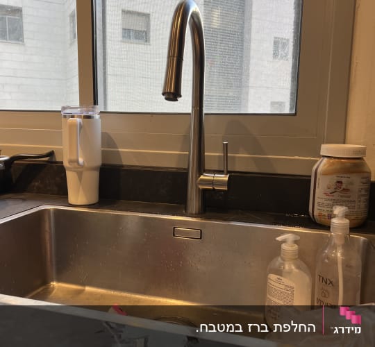 ברז נירוסטה מעל כיור מטבח עם סבון כלים